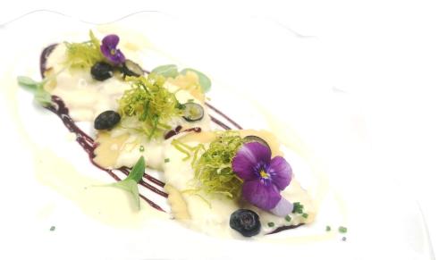 a plate of food with a purple flower on it at Hotel Antines in La Villa
