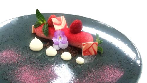 a plate of food with strawberries and chocolate on it at Hotel Antines in La Villa