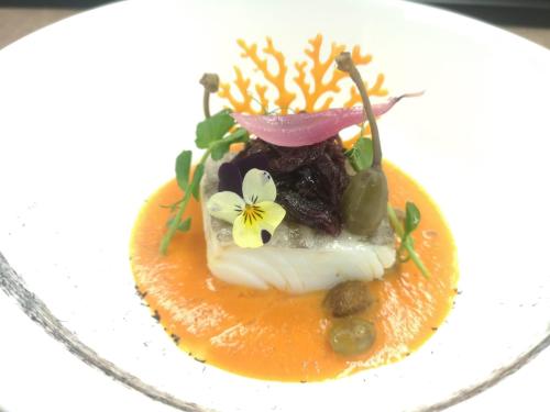 a dessert with a flower on top of an orange at Hotel Antines in La Villa