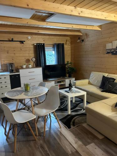 a living room with a couch and a table and chairs at Jagoda in Brenna