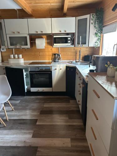 a kitchen with white appliances and wooden cabinets at Jagoda in Brenna