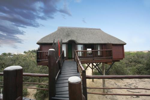 a hut on the beach with a wooden walkway at Stiltz Guest House in Swakopmund
