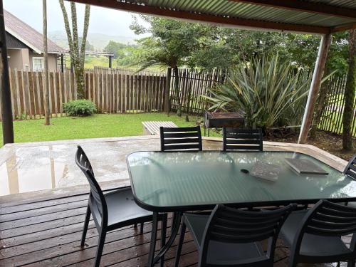 a patio with a table and chairs on a deck at Le Soleil in Graskop