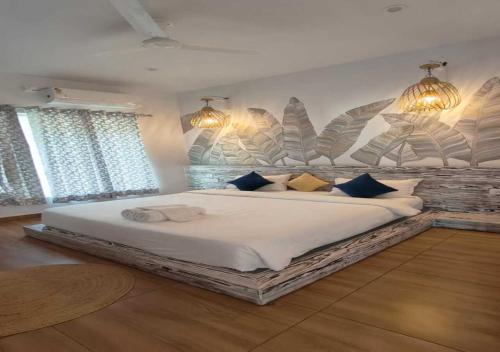 a bedroom with a large white bed with blue pillows at ALPINE BNB Dharmshala Homestay in Dharamshala