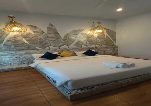 a bedroom with a large white bed with blue pillows at ALPINE BNB Dharmshala in Dharamshala