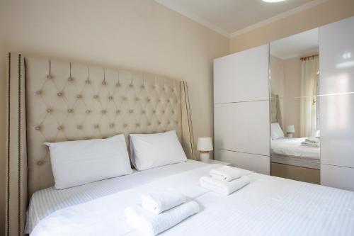 a bedroom with a large white bed with towels on it at Montesan Luxury Apartment Beach Front in Sveti Stefan
