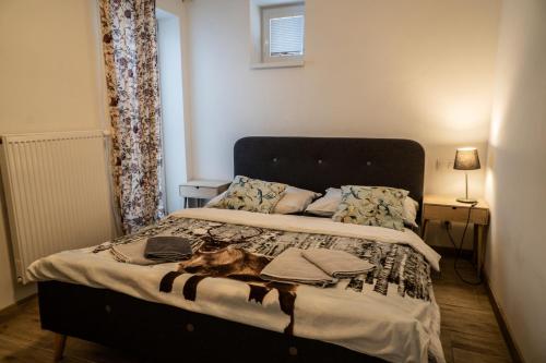a bedroom with a bed with a dog laying on it at Varalja Apartments in Plavecké Podhradie
