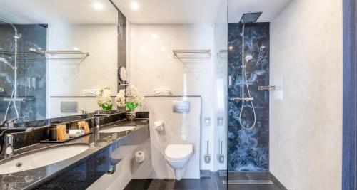 a bathroom with a sink and a toilet and a shower at PLAZA Premium Schwerin Sure Hotel Collection by Best Western in Schwerin