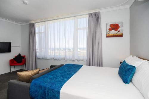 a hotel room with a bed and a couch at Ocean Drive Motel in Bunbury