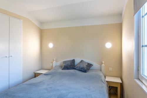 ein Schlafzimmer mit einem Bett mit zwei Kissen darauf in der Unterkunft Maison Village Port-Bourgenay in Saint-Hilaire-de-Talmont