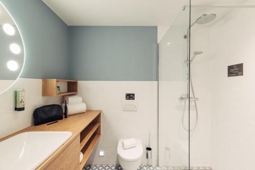a bathroom with a tub and a toilet and a shower at harry's home Graz-Smart City hotel & apartments in Graz