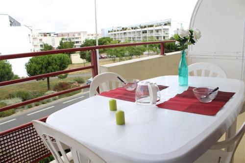 une table blanche et des chaises sur un balcon dans l'établissement Appt Studio LA ROCHELLE - LR010-212, à La Rochelle