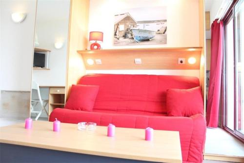 - un salon avec un canapé rouge et des oreillers roses dans l'établissement Appt Studio LA ROCHELLE - LR010-212, à La Rochelle
