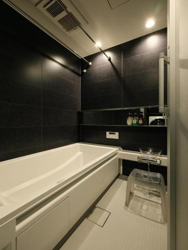 a bathroom with a white tub and black walls at SKY KYOTO in Kyoto