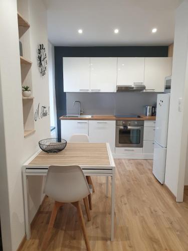 une cuisine avec une table et des chaises dans une pièce dans l'établissement Appartement agréable en plein cœur de ville, à Raon-lʼÉtape