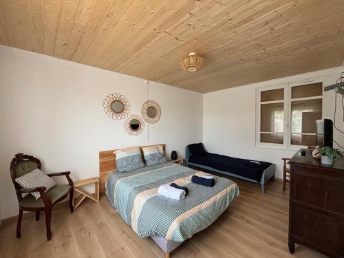 a bedroom with a bed and a couch in it at La p'tite camargue in Le Crotoy