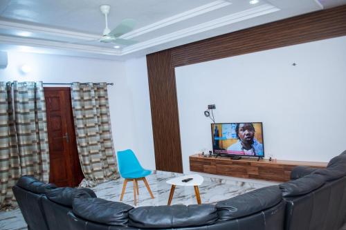 a living room with a couch and a flat screen tv at La Marina 2 in Cotonou