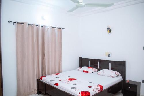 a bedroom with a bed with red and white pillows at La Marina 2 in Cotonou