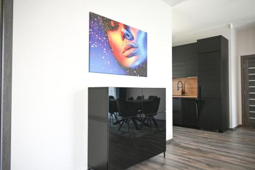a living room with a painting on the wall at Kintų Perlas Villa 4A in Kintai