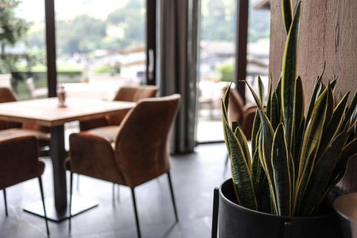 a table and chairs and a potted plant in a restaurant at Metzgerwirt in Hippach