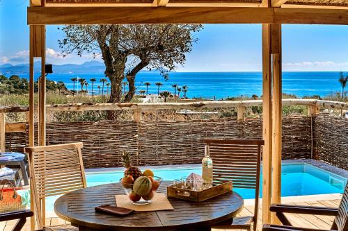 a patio with a table with a view of the ocean at Camping Au Paradis des Campeurs Premium in Roquebrune-sur-Argens