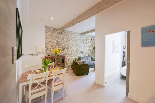 une salle à manger et un salon avec une table et des chaises dans l'établissement VIEUX MURS - Brand new flat for 4, AC, WIFI center old Antibes, à Antibes