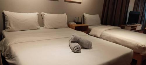コタキナバルにあるK Avenue by Kansayan Homestayのホテルの部屋にはタオルが敷かれたベッドが2つある