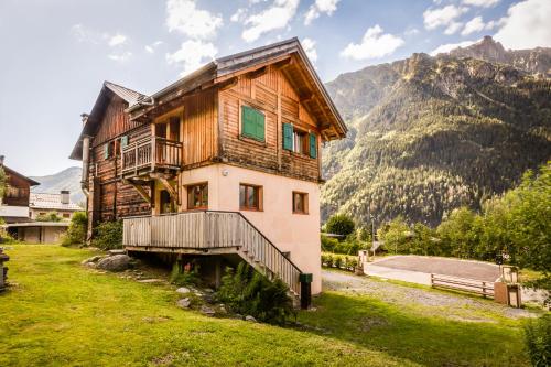 une maison sur une colline avec des montagnes en arrière-plan dans l'établissement Chalet Para, à Chamonix-Mont-Blanc
