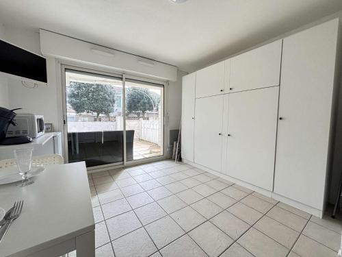 une cuisine avec des placards blancs et une grande fenêtre dans l'établissement Appt 1 pièce CHATELAILLON PLAGE - CL090-021, à Châtelaillon-Plage
