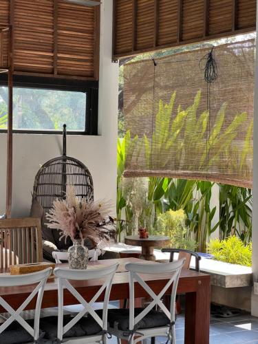 a dining room with a table and chairs and windows at ChiangMai清迈 cozy pool Villa 8rooms in Chiang Mai