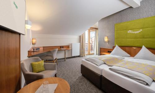 Pokój hotelowy z łóżkiem i biurkiem w obiekcie Hotel Königgut w mieście Wals-Siezenheim