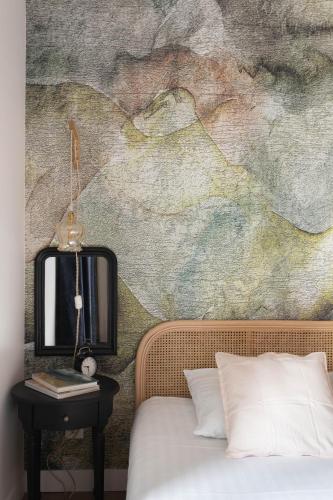 - une chambre avec un tableau mural à côté d'un lit dans l'établissement L'Ar Zénith - à 5min de l'Intra-Muros, à Saint-Malo