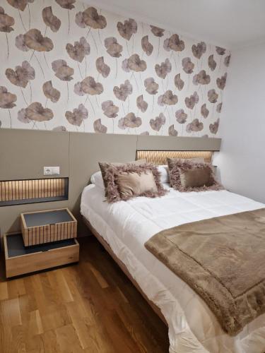 a bedroom with a bed and a wall with flowers at La Flor del Cantábrico in Ribadeo