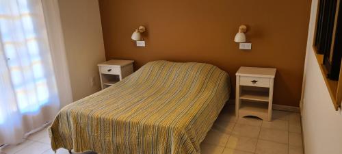 une petite chambre avec un lit et 2 tables de chevet dans l'établissement La Maison du Coq, à Gréoux-les-Bains