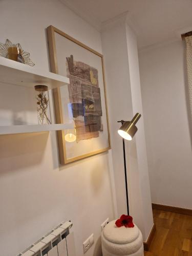 a room with a lamp and a white wall at La Flor del Cantábrico in Ribadeo