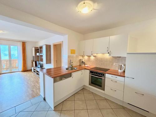 a kitchen with white cabinets and a counter top at FeWo Ortler auf dem Familien- & Tierfreundlichen Haslinger Hof in Saltusio