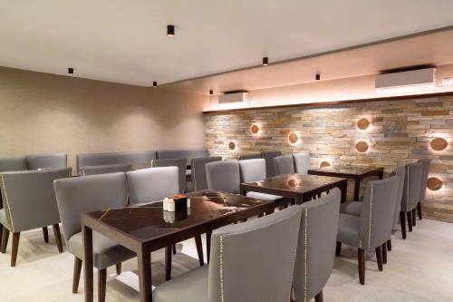 a dining room with tables and chairs and a brick wall at ila comfort in Bāglung