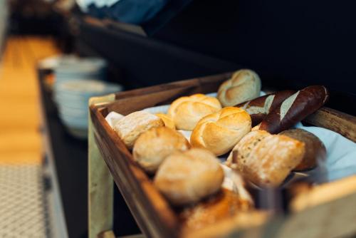 a tray of bread and pastries on a plate at harry's home Graz-Smart City hotel & apartments in Graz