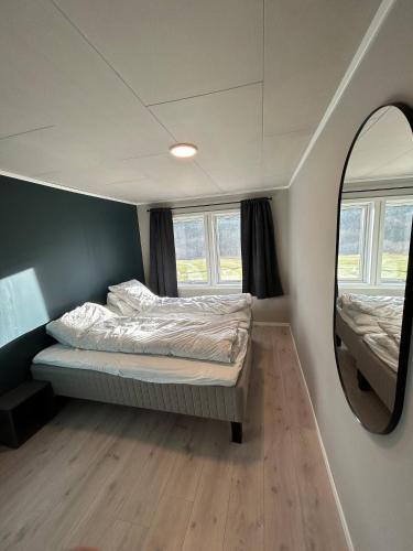 a small bedroom with a bed and a mirror at Beautiful Villa in Isfjorde in Isfjorden