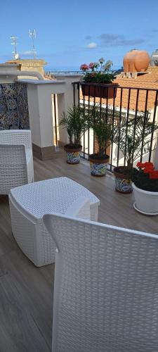 a white table and chairs on a balcony with the ocean at Regina Stella in Lascari