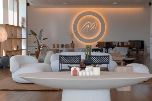 a living room with white furniture and a table at Malates Slow Boutique Hotel in Foz