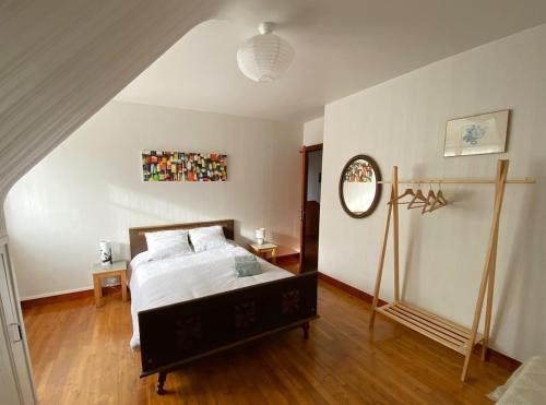 une chambre avec un lit et un miroir au mur dans l'établissement Maison confortable 7 personnes proche plage Crozon Morgat, à Crozon