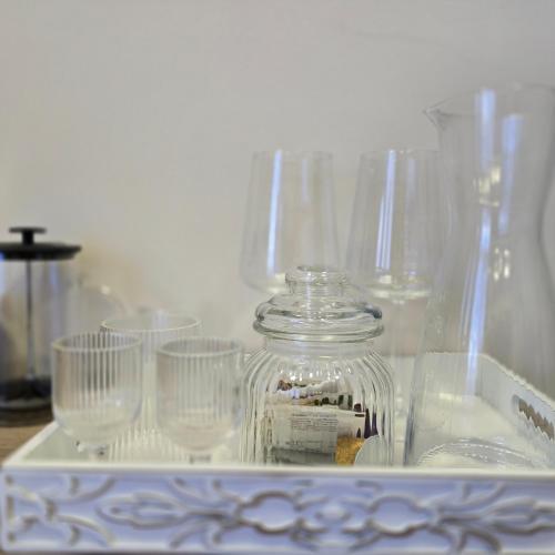 a glass jar with four empty glasses on a table at MA DONNA rooms in Floreşti