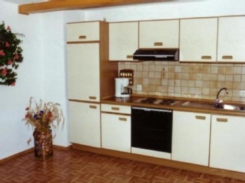 a kitchen with white cabinets and a stove top oven at FEWO Prackenbach in Prackenbach