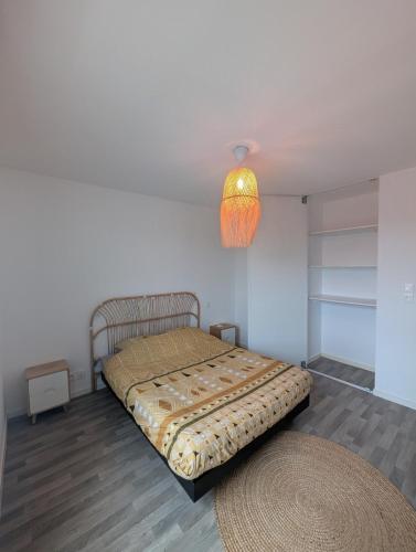 a bedroom with a bed with a lamp and a rug at Le Panoramique in Hennebont