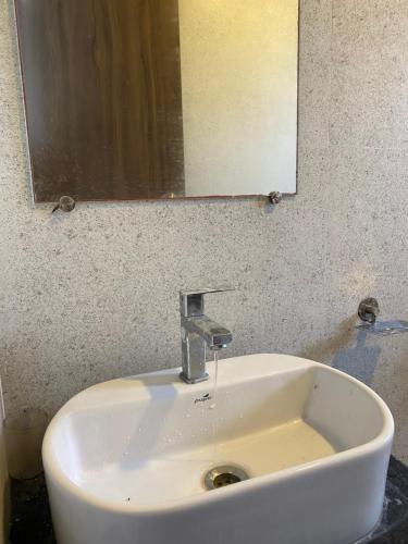 a white sink in a bathroom with a mirror at The Byke Skylark Seafront Resort, Dapoli in Murūd