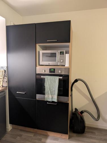 une armoire noire avec un four micro-ondes dans la cuisine dans l'établissement Le Panoramique, à Hennebont