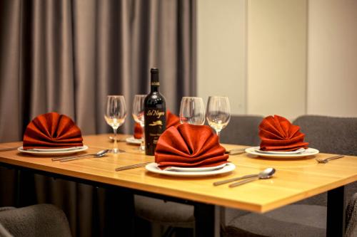 a wooden table with a bottle of wine and glasses at Lapland Dream House in Ivalo