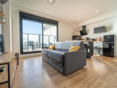 un salon avec un canapé et une grande fenêtre dans l'établissement Charmant appartement à 200m de l'océan avec terrasse et parking - FR-1-50-157, à Mimizan