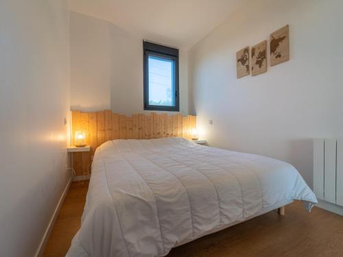 une chambre avec un grand lit blanc et une fenêtre dans l'établissement Charmant appartement à 200m de l'océan avec terrasse et parking - FR-1-50-157, à Mimizan
